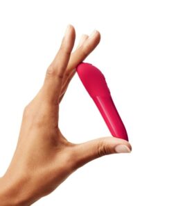 Hand holding a cherry Red colored We-Vibe Tango X bullet vibrator diagonallyÂ on a white background