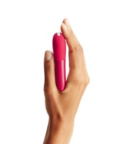 Hand holding a cherry Red colored We-Vibe Tango X bullet vibrator straight up on a white background