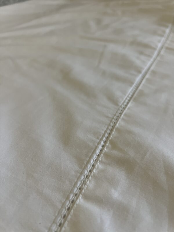 The top of the sheet has some detailed stitching.