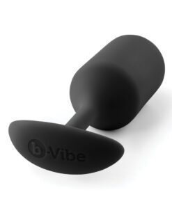 Large sized, black Snug Plug butt plug covered withÂ  silicone laying on its side on a white background